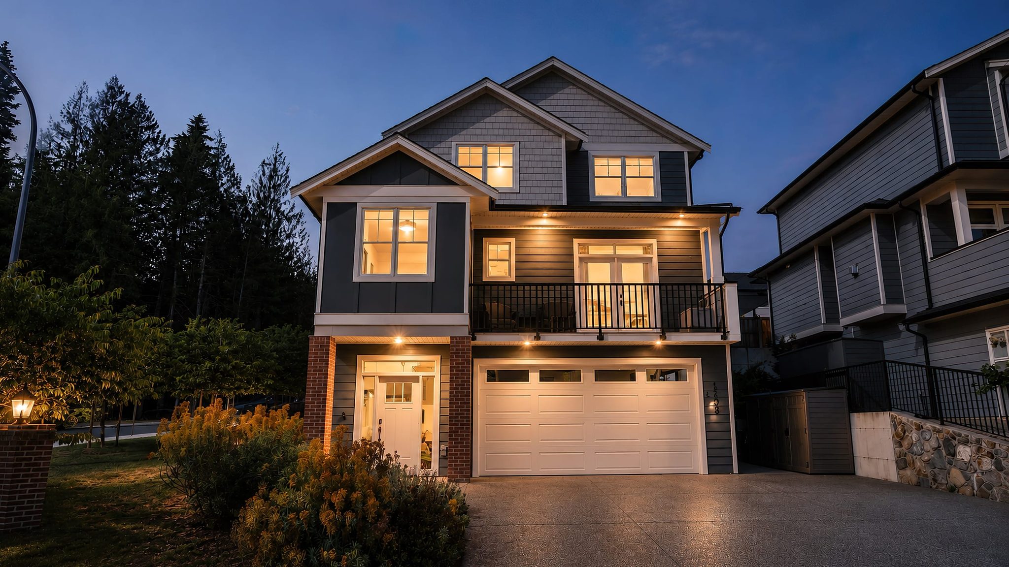 New-build family home photographed at dusk with the windows lit