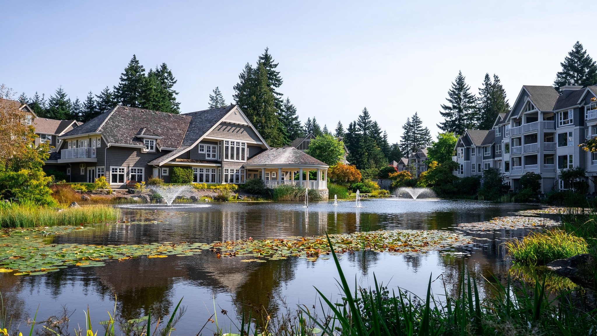 Shingle-style resort clubhouse beside a fountain pond at Bear Mountain