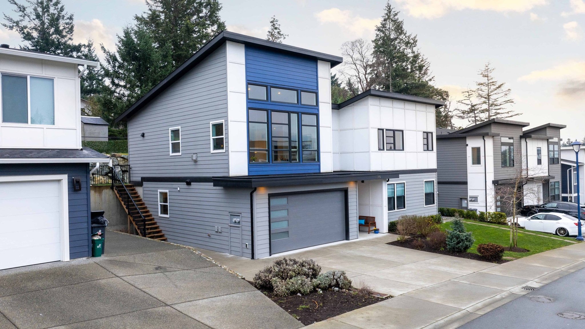 Dusk exterior of a modern grey and blue two-story home in Victoria BC