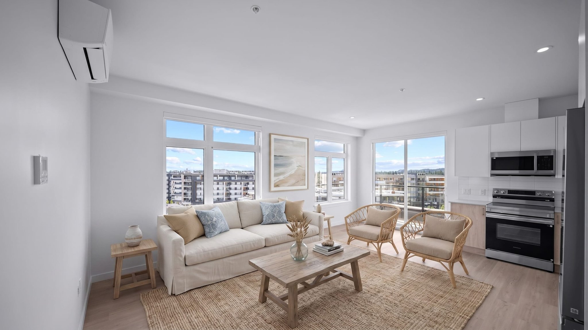 Bright condo living room and kitchen with floor-to-ceiling city-view windows